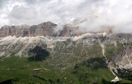 Landschaftsbild mit Blick auf das Sellamassiv und den teilweise wolkenverhangenen Piz Boe in den Dolomiten, Südtirol, Italien