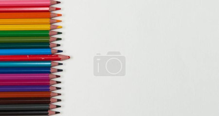 Hintergrund, Reihe heller Buntstifte mit einem alten Bleistift isoliert auf weißem Hintergrund