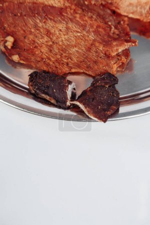 Foto de Carne curada carne de marco completo de primer plano. trozos pequeños y delgados cortados en triángulos - Imagen libre de derechos