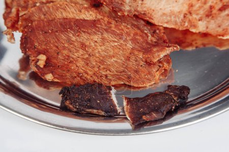 Foto de Carne curada carne de marco completo de primer plano. trozos pequeños y delgados cortados en triángulos - Imagen libre de derechos