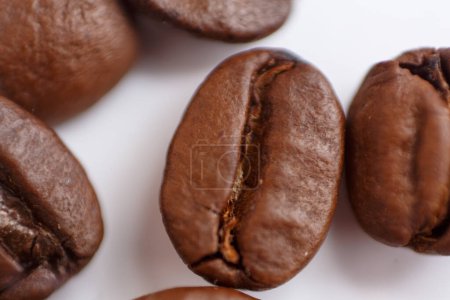 Foto de Several grains of roasted coffee on a white background. macro. photographed with an old lens with blurring around the edges, and with a shallow depth of field. very large. High quality photo - Imagen libre de derechos