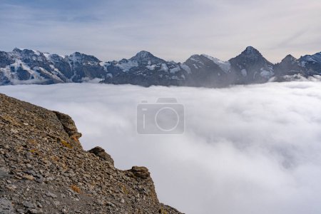 Blick auf die Schweizer Alpen über Wolken an einem sonnigen Tag vom Schilthorngipfel in der Schweiz