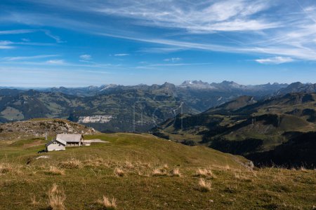 Cabaña de montaña y teleférico visto desde la cumbre de Fronalpstock, Suiza. Vista icónica de los Alpes suizos