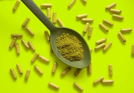 Photo for Kratom pills composition on yellow background with kratom filled - Royalty Free Image