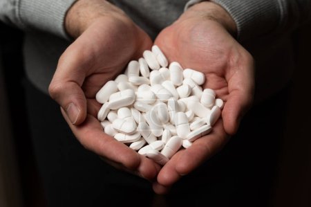 Photo for Male hands hold pile of white medicine tabs pills, concept of wellness - Royalty Free Image
