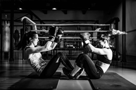 Photo for Women on boxing training doing crunches - Royalty Free Image