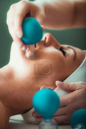 Téléchargez les photos : Cupping thérapie, ventosa gobelet traitement du visage dans un salon de beauté - en image libre de droit