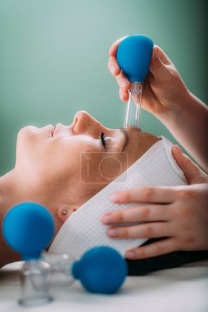 Téléchargez les photos : Cupping thérapie, ventosa gobelet traitement du visage dans un salon de beauté - en image libre de droit