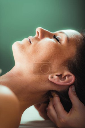 Photo for Neck massage in a massage salon, woman having a relaxing neck massage. - Royalty Free Image