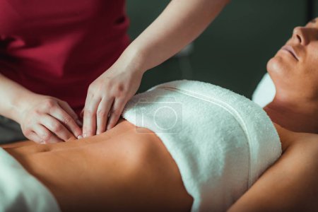 Téléchargez les photos : Salon de massage, femme ayant un massage de l'estomac. - en image libre de droit
