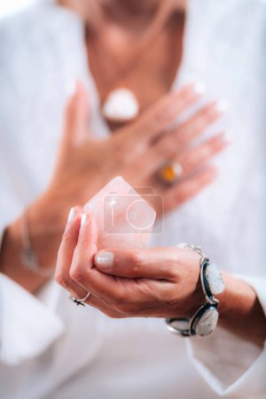Photo for Self-esteem concept. Hand holding a rose quartz crystal, boosting feeling of self-esteem and self-love, improving mood and harmony - Royalty Free Image