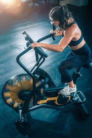 Téléchargez les photos : Cardio-entraînement. Femme utilisant Air Bike dans la salle de gym. - en image libre de droit