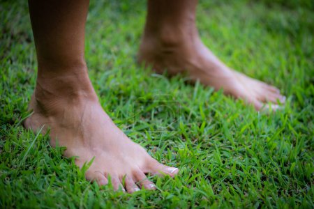 Photo for Grounding practice, barefoot woman standing on the grass. - Royalty Free Image