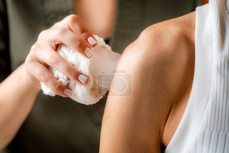 Téléchargez les photos : Massage sur glace des blessures aux épaules. - en image libre de droit