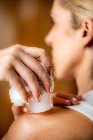 Photo for Shoulder cryotherapy ice massage. Hands of a therapist placing ice directly onto a painful shoulder to relieve pain, reduce inflammation and swelling and promote healing. - Royalty Free Image