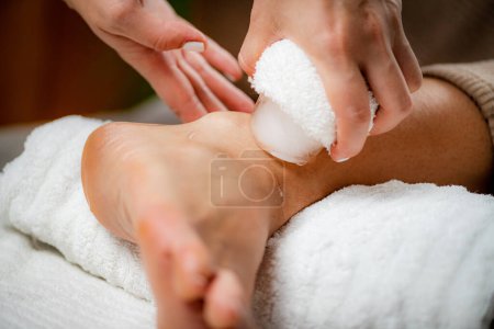 Téléchargez les photos : Massage sur glace aux blessures au poignet. Mains d'un thérapeute plaçant de la glace directement sur un poignet douloureux pour soulager la douleur, réduire l'inflammation et le gonflement et favoriser la guérison. - en image libre de droit