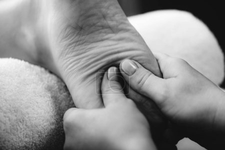 Téléchargez les photos : Massage relaxant des pieds, mains d'une massothérapeute féminine massant les pieds des clientes. - en image libre de droit