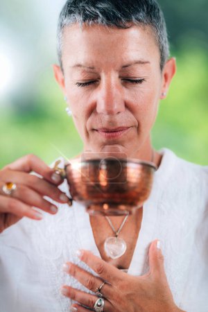 Photo for European woman enjoying a cup of ceremonial tea, practicing mindfulness - Royalty Free Image