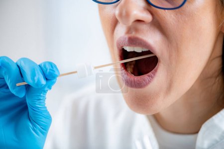 Photo for Woman Taking a mouth swab for DNA analysis - Royalty Free Image