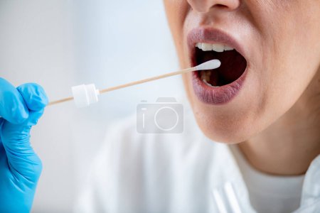 Photo for Woman Taking a mouth swab for DNA analysis - Royalty Free Image