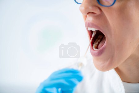 Foto de Woman Taking a mouth swab for DNA analysis - Imagen libre de derechos