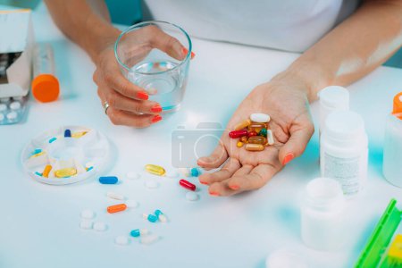Photo for Supplementation. Woman holding a myriad of vitamin and mineral supplements in her hand. - Royalty Free Image