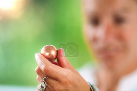 Foto de Contemplation for inner peace and serenity. Spiritual healer holding an energized copper ball, demonstrating a calming meditation technique for inner peace and serenity - Imagen libre de derechos