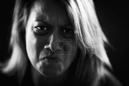 Photo for Anger - intense portrait of an angry woman on black background - Royalty Free Image