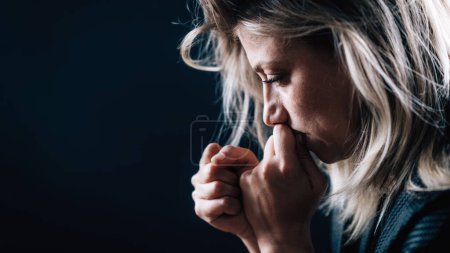 Téléchargez les photos : Anxiety mental disorder  portrait of a troubled woman on black background - en image libre de droit