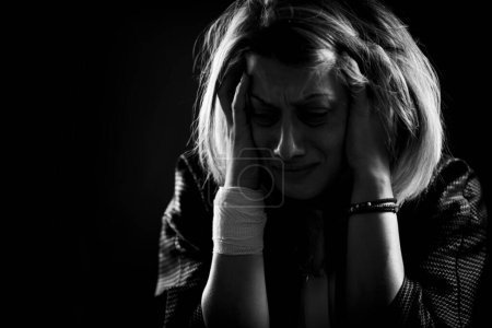 Foto de Anxiety disorder concept - portrait of anxious woman on a dark background - Imagen libre de derechos