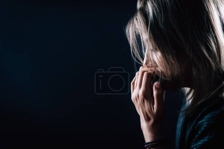 Téléchargez les photos : Anxiété trouble mental portrait d'une femme troublée sur fond noir - en image libre de droit