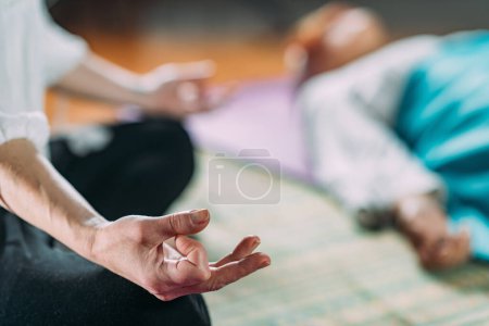 Téléchargez les photos : Méditation guidée. Gros plan sur la main des femmes, méditant, assis en position lotus
. - en image libre de droit