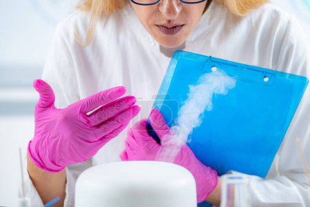 Téléchargez les photos : Scientifique de laboratoire olfactif prenant des notes pendant l'essai d'huile essentielle d'arôme - en image libre de droit