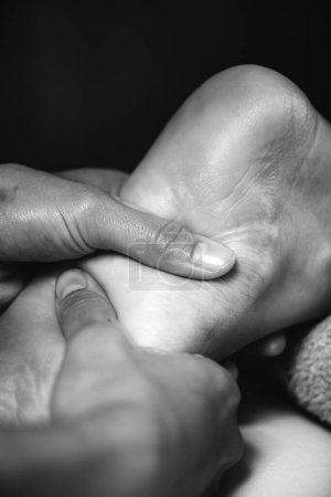 Téléchargez les photos : Ayurvedic Foot Massage. Hands of Ayurveda Practitioner massaging female foot - en image libre de droit