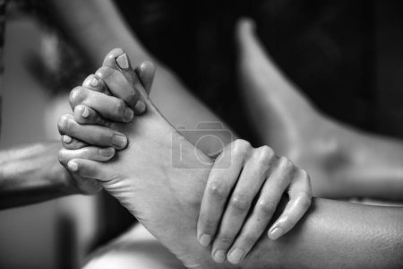 Téléchargez les photos : Ayurvedic Foot Massage. Hands of Ayurveda Practitioner massaging female foot - en image libre de droit