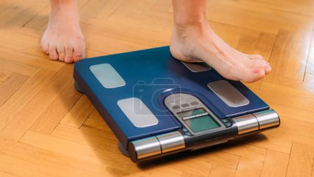 Téléchargez les photos : Gros plan de la femme debout sur le Body Fat Scale - en image libre de droit