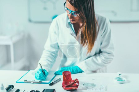 Photo for Forensic Science in Lab. Forensic Scientist examining shoe with evidences - Royalty Free Image