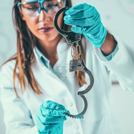 Photo for Forensic Science in Lab. Forensic Scientist examining handcuff with evidences - Royalty Free Image