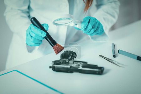 Foto de Ciencias forenses en el laboratorio. Científico forense examinando arma con evidencias - Imagen libre de derechos