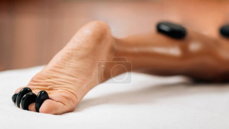 Photo for Stone massage feet treatment in a wellness center - Royalty Free Image