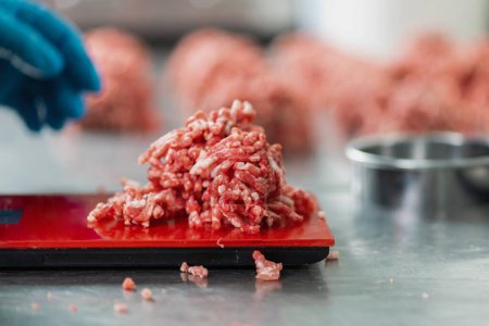 Foto de Medición de carne picada de res para la preparación de hamburguesas en un kitche comercial - Imagen libre de derechos