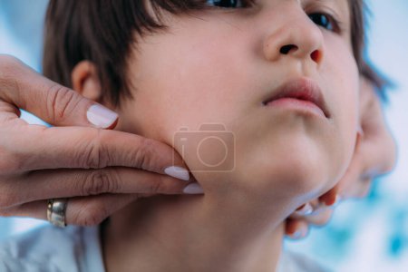 Photo for Endocrinology pediatrics specialist, medical doctor specialized in the diagnosis and treatment of hormonal disorders, examining boys lymph nodes - Royalty Free Image