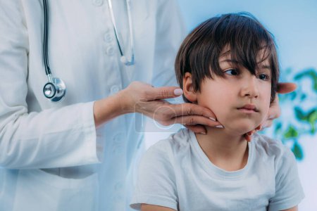 Endocrinology pediatrics specialist, medical doctor specialized in the diagnosis and treatment of hormonal disorders, examining boys lymph nodes 