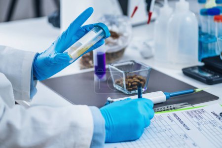 Photo for Sample preparation for pet food quality control in laboratory. Lab technician marking samples for pet food safety test - Royalty Free Image