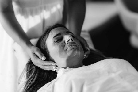 Téléchargez les photos : Thérapeute Reiki Transfert d'énergie. Femme paisible couché avec ses yeux fermés
. - en image libre de droit