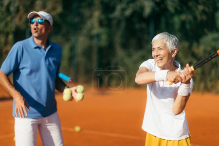 Téléchargez les photos : Professeur de tennis avec femme senior, cours de tennis - en image libre de droit