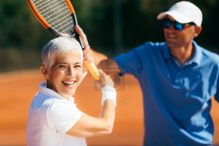 Téléchargez les photos : Instructeur de tennis Enseignement aux femmes âgées Comment jouer au tennis - en image libre de droit