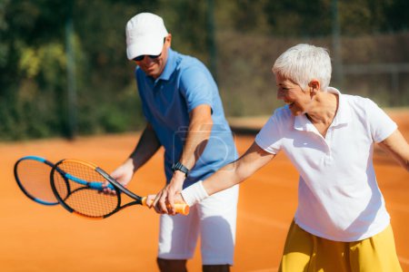 Téléchargez les photos : Entraînement de tennis pour seniors avec instructeur - en image libre de droit