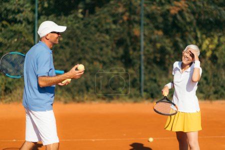 Téléchargez les photos : Professeur de tennis avec femme senior, cours de tennis - en image libre de droit