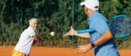Foto de Mujer mayor activa practicando tenis con instructor - Imagen libre de derechos